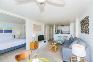 檀香山Ilikai Marina 692的一间卧室和一间带床和沙发的客厅