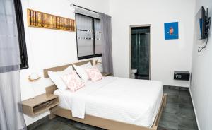 圣多明各Hotelito Bonito Eli & Edw的一间卧室配有带白色床单和粉红色枕头的床。