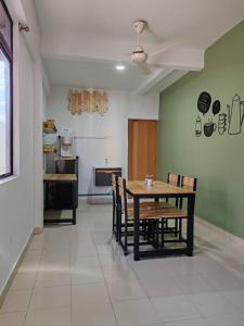 哥打巴鲁Suite Us Guesthouse Kubang Kerian的一间带桌椅的用餐室和一间厨房