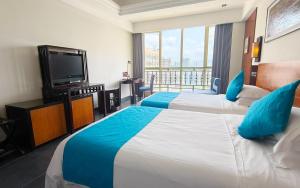 三亚三亚胜意海景度假酒店的酒店客房设有两张床和一台平面电视。
