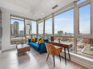 多伦多Boutique Vista Two Bedroom Suite - Toronto's Entertainment District的客厅设有蓝色的沙发和大窗户