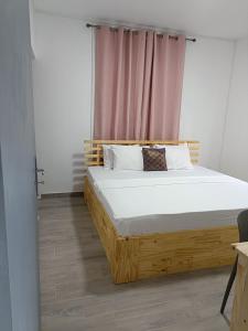 格兰高伯Cozy Lodge的卧室在窗户前配有木床