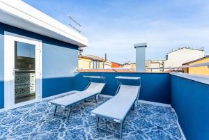 索托马里纳La Bella Vita - La Terrazza的阳台配有椅子和蓝色的墙壁