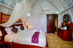珀尼达岛Hotra Hill Cottage的一间卧室配有一张带蚊帐的床