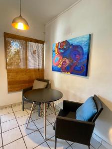 圣何塞德尔卡沃Casa Kante的配有桌椅和绘画的房间