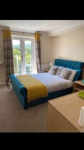 克里克豪厄尔Llanwenarth Hotel的一间卧室设有蓝色的床和窗户。