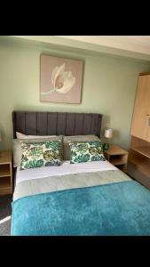 克里克豪厄尔Llanwenarth Hotel的一间卧室配有一张大床,提供蓝色的床单和枕头