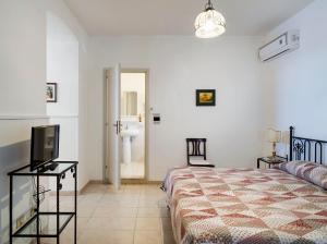 陶尔米纳贝尔索基欧诺酒店的一间卧室配有一张床和一台电视,还设有一间浴室
