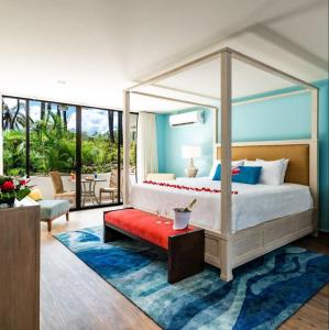 普拉亚弗拉明戈Margaritaville Beach Resort - Honeymoon suite - Costa Rica的一间卧室配有一张带红色长凳的天蓬床