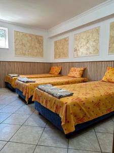 萨图马雷Hanul Lui Ionut的一间设有两张带橙色床单的床的房间