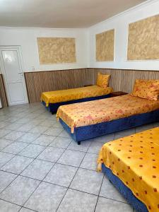 萨图马雷Hanul Lui Ionut的配有黄色和橙色床单的三张床