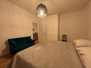 VeytauxGrand Appartement Lumineux - STELLA Loft - À deux pas du Lac Léman的一间卧室配有一张床和一张蓝色椅子