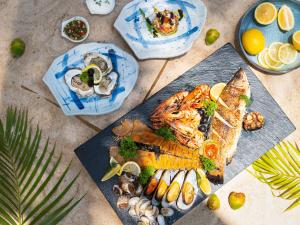 湄南海滩Explorar Koh Samui - Adults Only Resort and Spa的桌上一盘带鱼和蔬菜的食物