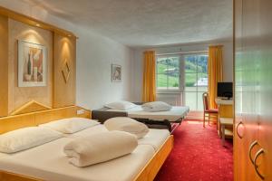 耶岑斯皇家阿尔卑斯山酒店的酒店客房设有两张床、一张桌子和一台电视。