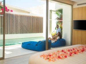 湄南海滩Explorar Koh Samui - Adults Only Resort and Spa的坐在酒店房间沙发上的一对夫妇