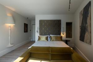 卡尼洛瑞维拉阿兰希奥马洛酒店的一间卧室配有一张大床和大床头板