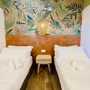 泰拉奇纳棕榈村公寓的一间设有两张床的房间和一堵植物墙