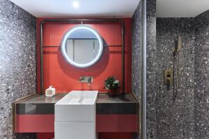 北京M·酒店(北京天安门广场前门地铁站店)的浴室设有红色的墙壁和镜子