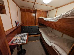 特罗姆瑟Fjordbooking的小房间设有两张双层床和一张桌子