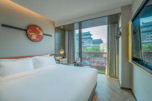 北京M·酒店(北京天安门广场前门地铁站店)的一间卧室设有一张大床和一个大窗户
