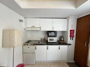 伦敦Stay in Bloomsbury1的白色的厨房配有水槽和微波炉
