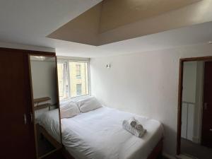 伦敦Stay in Bloomsbury1的一间卧室配有一张带白色床单的床和一扇窗户。