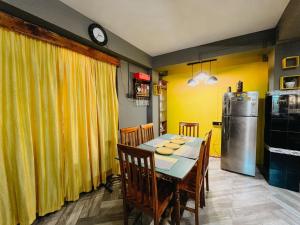 甘托克StayCation Homestay的一间带桌子和冰箱的用餐室