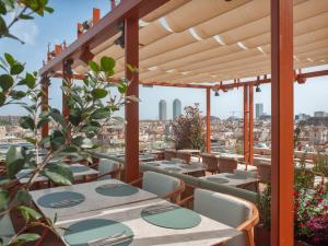 巴塞罗那Grand Hotel Central, Small Luxury Hotels的一个带桌椅的庭院,享有城市美景。