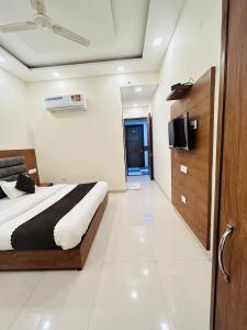 钱德加尔Hotel Wood Lark Zirakpur Chandigarh- A unit of Sidham Group of Hotels的一间卧室配有一张床,墙上配有电视