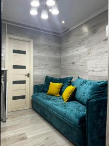 基希讷乌Apartment的客房内的蓝色沙发,配有两个黄色枕头