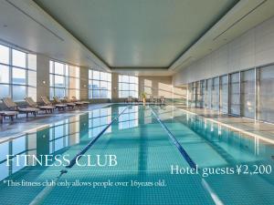 东京东京台场日航大酒店的一座带椅子的建筑内的游泳池