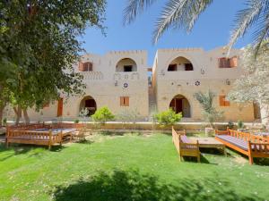 TunisZad El Mosafer Guest House的一个带长椅的庭院和一座建筑