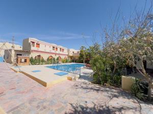 TunisZad El Mosafer Guest House的一座带游泳池的度假村,位于一座建筑旁边