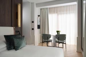 里乔内玛耶斯塔雷酒店的一间卧室配有一张床、两把椅子和一个窗户
