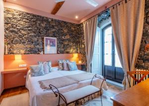 科伦加玛德尔苏夫酒店的一间卧室设有一张床和石墙