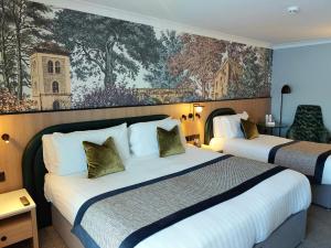 戈尔韦门罗公园酒店的酒店客房设有两张床,墙上挂有绘画作品