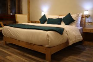 ShigarGuzel Hotel的一间卧室配有一张带绿色枕头的大床