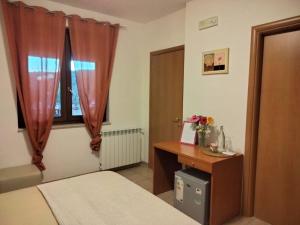 伊特里Casale di Valle Fredda的一间卧室配有一张床、一张书桌和一个窗户。