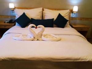 ShigarGuzel Hotel的两个天鹅 ⁇ 地 ⁇ 着,好像心似的坐在床上