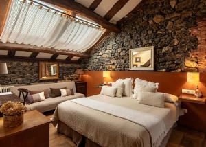 科伦加玛德尔苏夫酒店的一间卧室设有一张大床和石墙