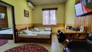 杜尚别Diamond Hotel Dushanbe的客房设有两张床、一张桌子和一张书桌。