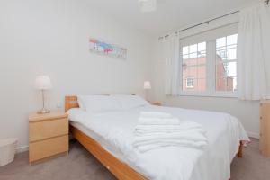 爱丁堡Attractive Edinburgh Leith Apartment的一间卧室配有一张带白色床单的床和一扇窗户。