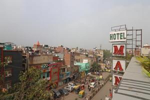 新德里Hotel Mannat at Paschim Vihar的城市,有酒店标志,街道繁忙