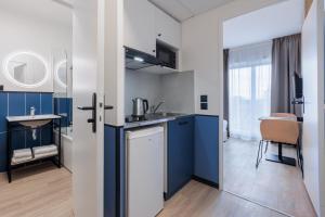 蒙泰夫兰杜帕尔克瓦尔欧洲公寓式酒店的厨房配有蓝白色橱柜和水槽