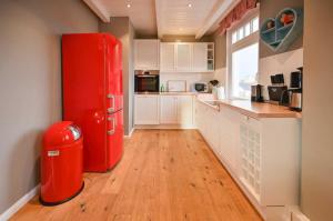 克伦胡森Maxi - Sonnenhof 4的铺有木地板的厨房里的一个红色冰箱
