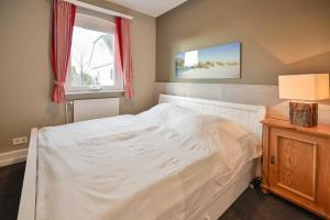 克伦胡森Maxi - Sonnenhof 4的卧室配有白色的床和窗户。