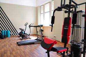 弗罗茨瓦夫波尼亚中枢酒店的健身房设有数台跑步机和红色椅子