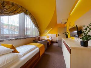 下厄尔什Hotel Mayer Alsóörs的酒店客房设有两张床和窗户。