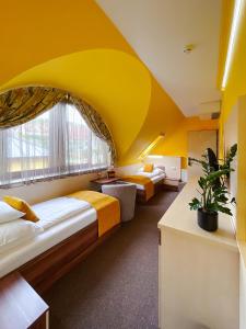 下厄尔什Hotel Mayer Alsóörs的黄色天花板的客房内的两张床