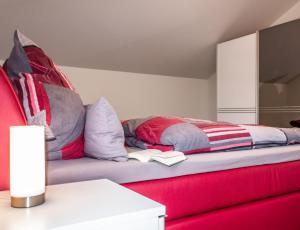哈夫克鲁格Neue Liebe Haffkrug 5 - Meeresstern的一间卧室配有红色的床,上面有一本书